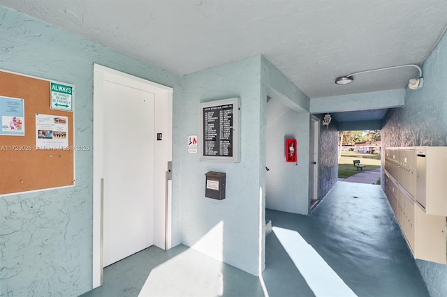 corridor with elevator and concrete floors