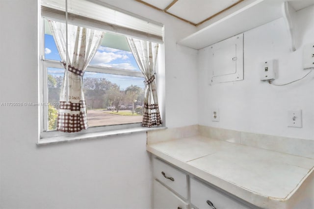 kitchen with electric panel and white cabinetry