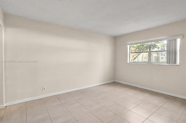 tiled empty room with a textured ceiling