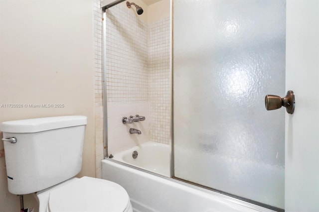 bathroom with bath / shower combo with glass door and toilet