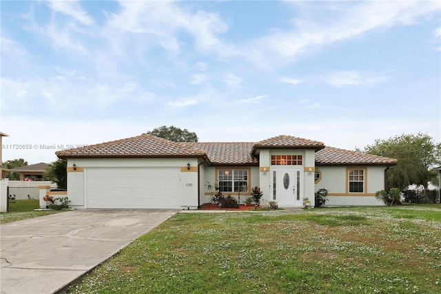 mediterranean / spanish house featuring a garage and a front lawn