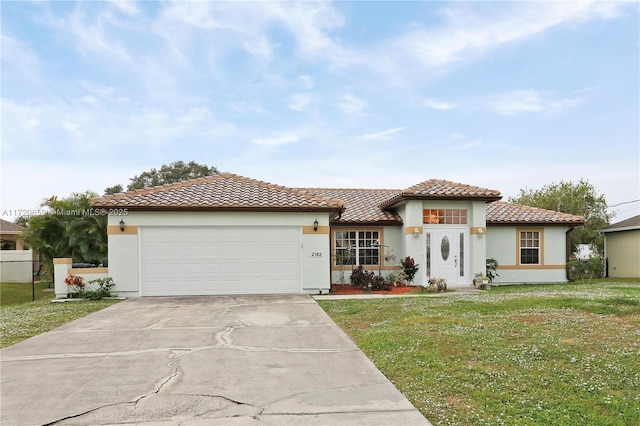 mediterranean / spanish house with a garage and a front yard