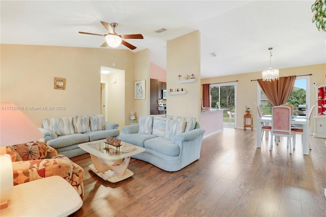 living room featuring vaulted ceiling, hardwood / wood-style floors, and ceiling fan with notable chandelier