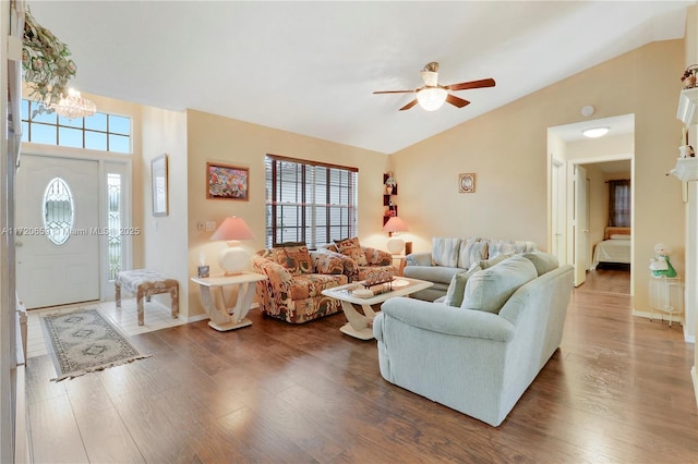 living room featuring vaulted ceiling, hardwood / wood-style floors, and ceiling fan with notable chandelier