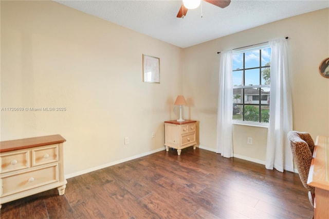 living area featuring ceiling fan and dark hardwood / wood-style flooring