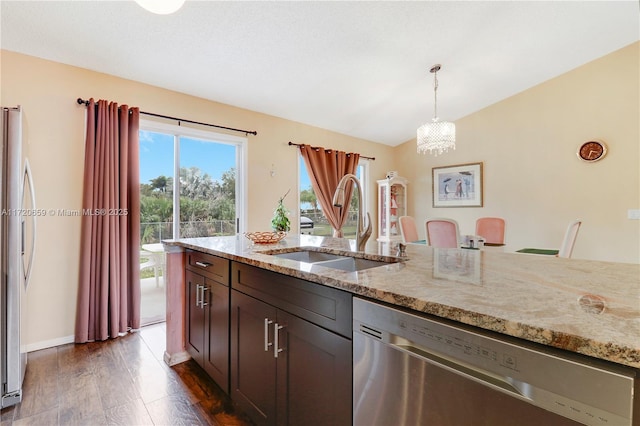 kitchen with light stone countertops, hanging light fixtures, appliances with stainless steel finishes, and dark wood-type flooring