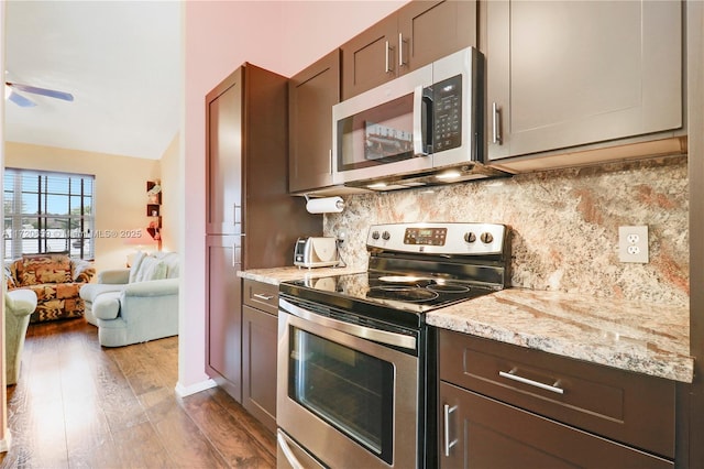 kitchen featuring backsplash, vaulted ceiling, ceiling fan, wood-type flooring, and stainless steel appliances