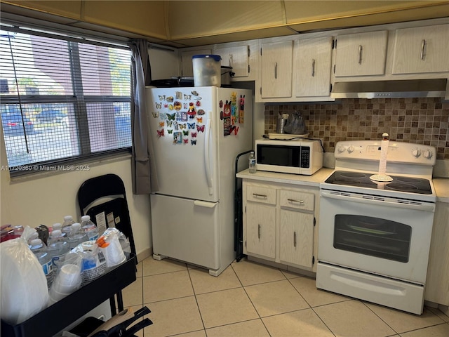 kitchen featuring light tile patterned floors, white appliances, and decorative backsplash