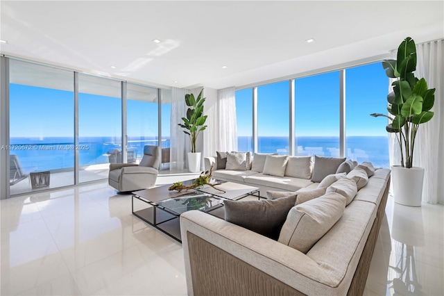 living room with a water view, plenty of natural light, floor to ceiling windows, and light tile patterned flooring