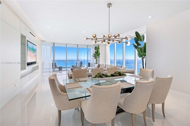 dining space with light tile patterned floors, a water view, floor to ceiling windows, and a notable chandelier