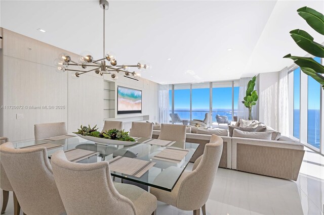 tiled dining space featuring floor to ceiling windows, a water view, built in features, and an inviting chandelier