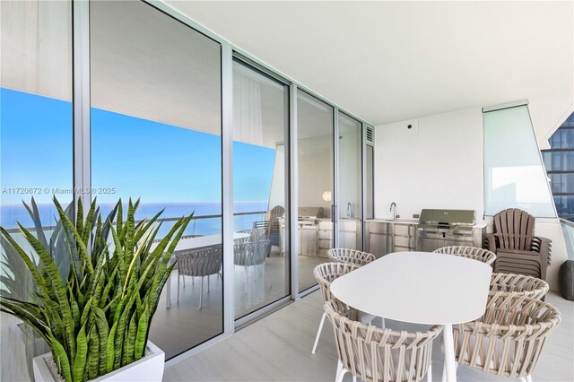 balcony featuring a water view, area for grilling, and a grill