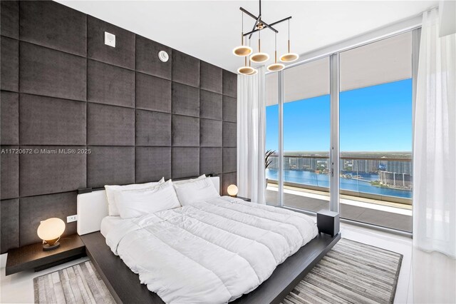 bedroom with a water view, a chandelier, and tile walls