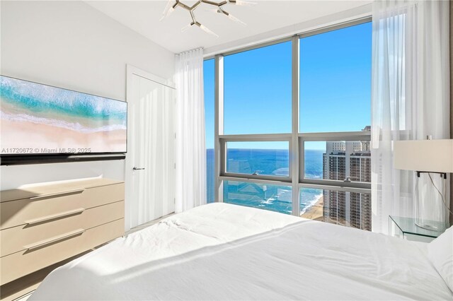 bedroom with a water view and multiple windows