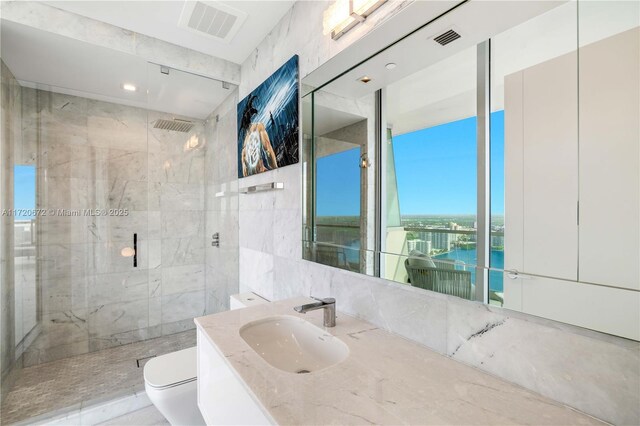 bathroom with walk in shower, vanity, tile walls, and toilet