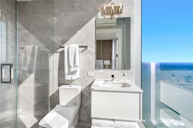 bathroom with vanity, a water view, toilet, tile walls, and an enclosed shower