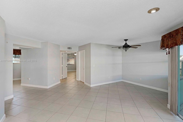 tiled spare room with ceiling fan and a textured ceiling