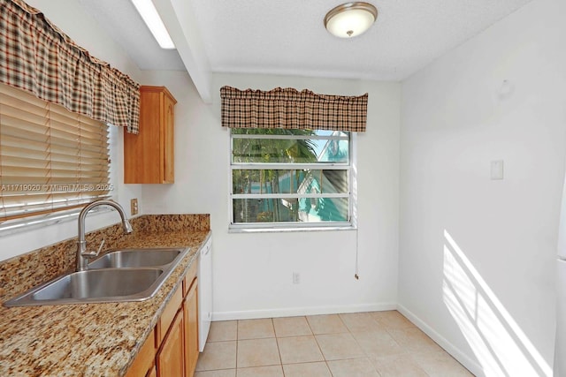 kitchen with light stone countertops, a textured ceiling, white dishwasher, sink, and light tile patterned flooring