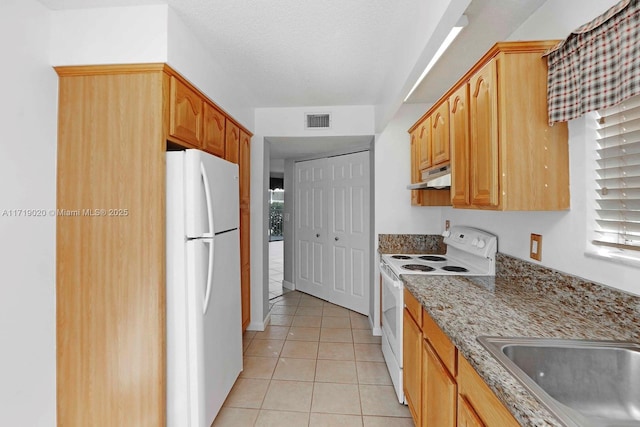 kitchen featuring light stone countertops, sink, light tile patterned floors, and white appliances