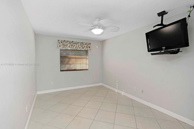 tiled spare room with a textured ceiling and ceiling fan