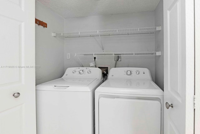 laundry room featuring washing machine and dryer and a textured ceiling