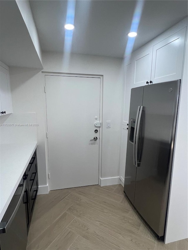 interior space with white cabinets and appliances with stainless steel finishes