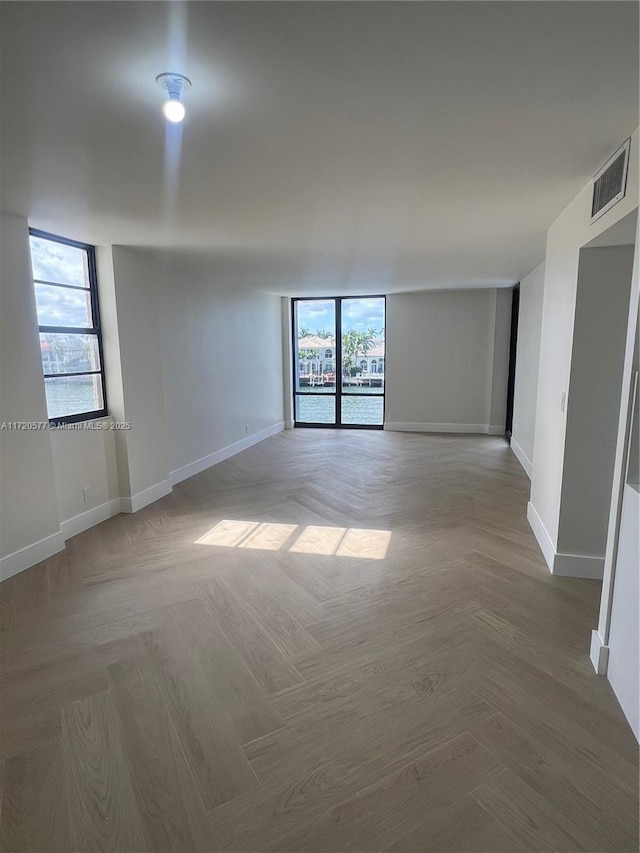 unfurnished room featuring parquet flooring and a wealth of natural light