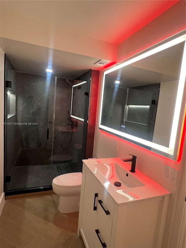 bathroom featuring vanity, an enclosed shower, and toilet