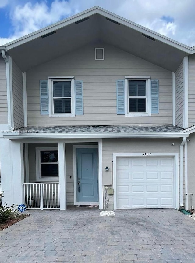 view of front property with covered porch and a garage