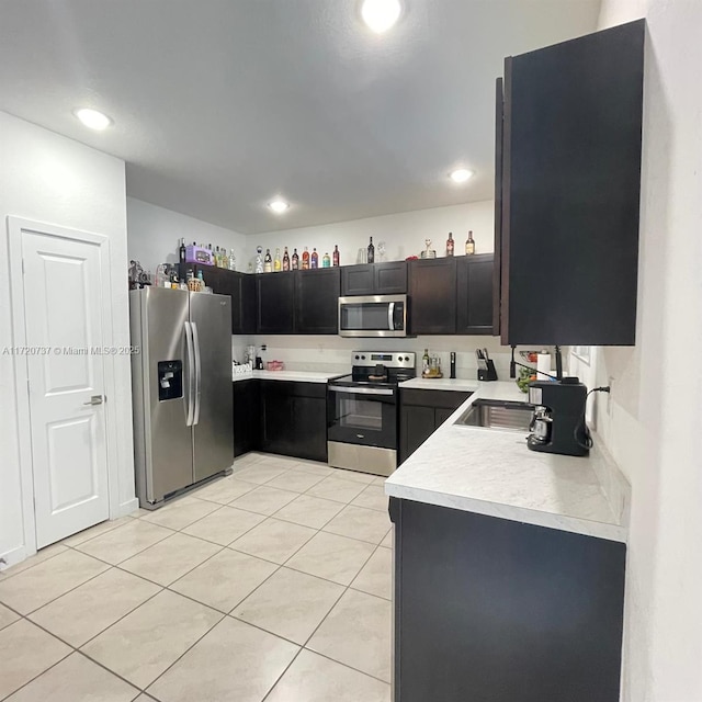 kitchen featuring sink, light tile patterned floors, and stainless steel appliances