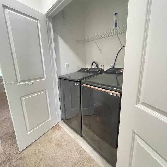 clothes washing area featuring light colored carpet and independent washer and dryer