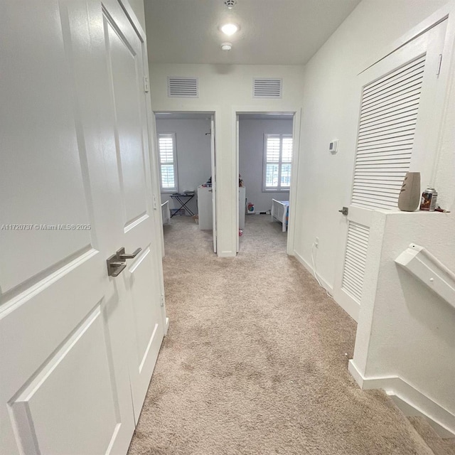 hallway with light colored carpet