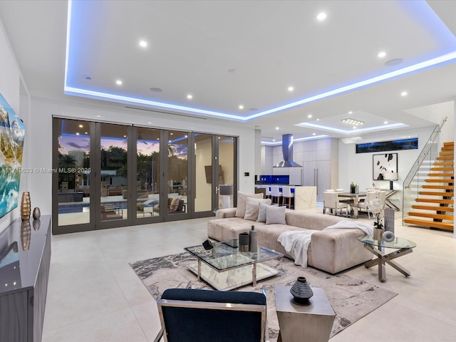 living area featuring stairway, a tray ceiling, french doors, and recessed lighting