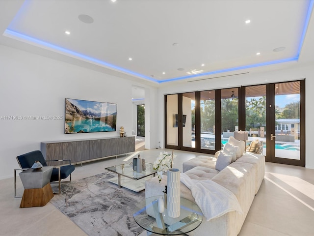 living area with recessed lighting, a raised ceiling, and french doors