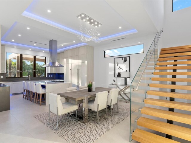 dining room with stairway, recessed lighting, a raised ceiling, and a notable chandelier