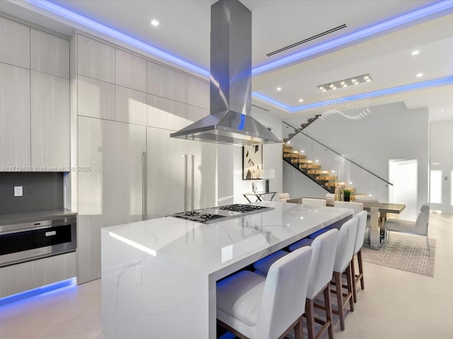 kitchen featuring a spacious island, modern cabinets, island exhaust hood, and stainless steel gas stovetop