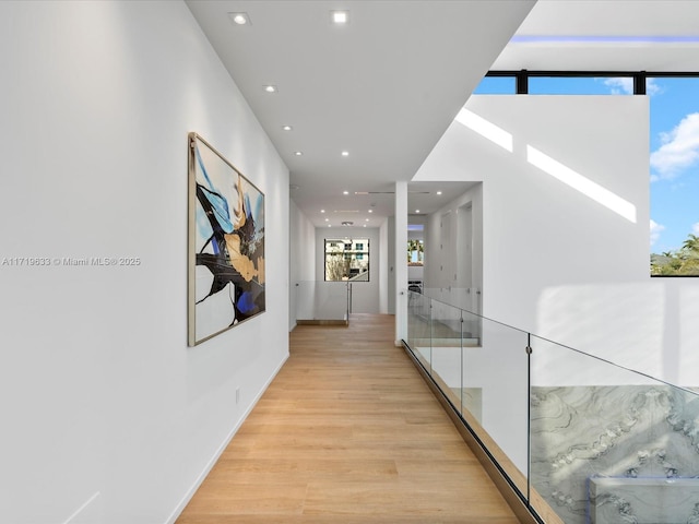 corridor featuring light wood-type flooring and recessed lighting