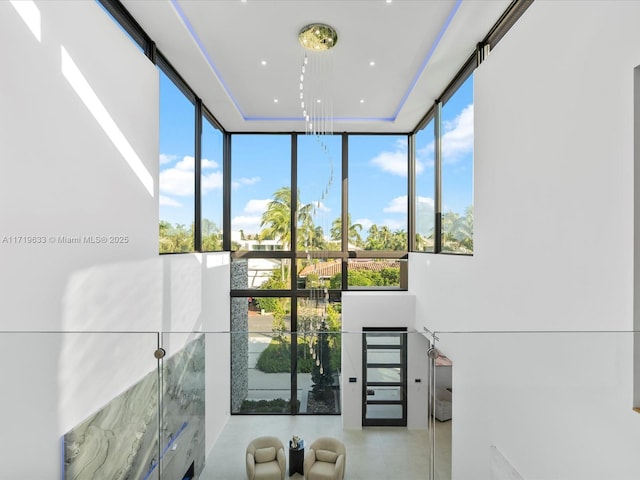 interior space featuring expansive windows, a high ceiling, and a healthy amount of sunlight