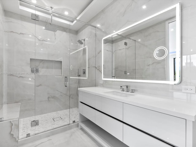 bathroom with marble finish floor, vanity, and a shower stall