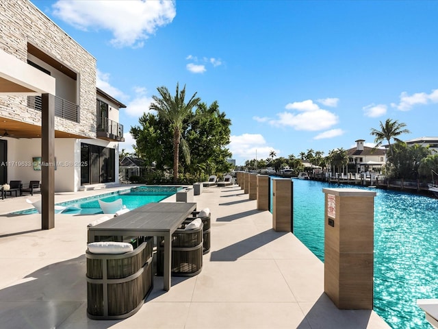 pool featuring a patio area and a water view