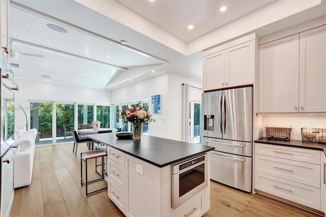 kitchen with lofted ceiling, stainless steel fridge with ice dispenser, and white cabinets