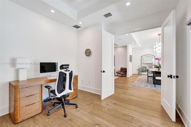 office area with a tray ceiling, a chandelier, and light hardwood / wood-style floors