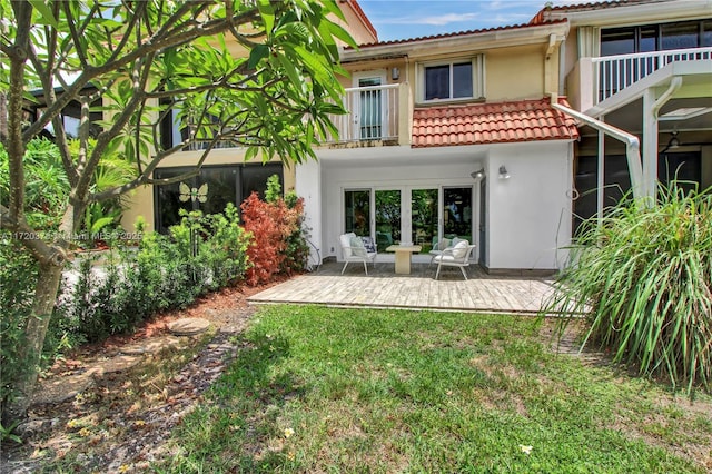 back of house with a lawn, a balcony, and a patio