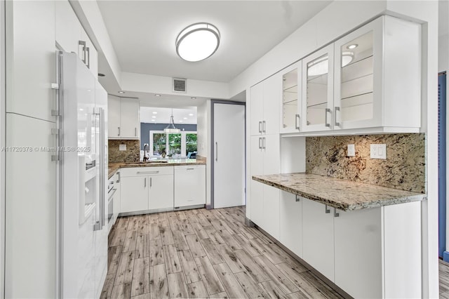 20416 NE 34th Ct Unit 17, Aventura, FL 33180 - kitchen featuring white appliances, glass insert cabinets, white cabinetry, tasteful backsplash, and light wood-style floors
