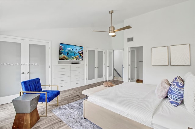 bedroom with ceiling fan, light wood-type flooring, high vaulted ceiling, and french doors