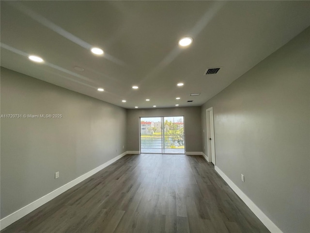 unfurnished room with dark hardwood / wood-style flooring