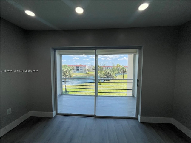 entryway with hardwood / wood-style flooring, plenty of natural light, and a water view