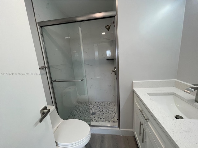 bathroom featuring toilet, hardwood / wood-style floors, vanity, and walk in shower