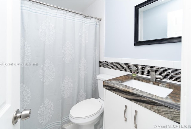 bathroom with backsplash, vanity, and toilet