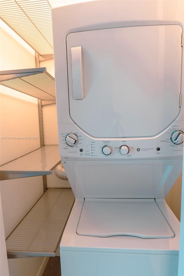 clothes washing area with stacked washer / dryer